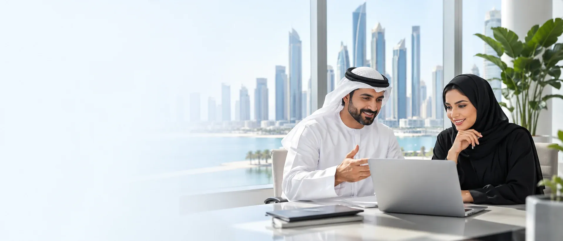 Two business colleagues discuss a laptop in a bright office